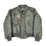 Green military-style jacket with patches on a white background