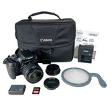 Canon DSLR camera kit with a black body, lens, carrying case, battery, charger, lens cap, SD card, and gray filter, arranged on a white background.