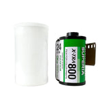 A vintage roll of Superia X-Tra 800 film for color prints stands next to a white plastic film canister on a light gray textured background.