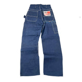 A pair of vintage blue denim jeans laid flat on a white surface, showing the back pockets and a red and white Levi's brand patch on the right back pocket.