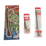 Three packaged novelty rifle-shaped items displayed on a white background: a large carded 'AI GARRISON RIFLE PEN' set with illustrated packaging, a smaller red-and-white package, and a taller clear plastic package containing a long metallic object.