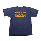 A navy blue short-sleeve t-shirt laid flat on a white fabric background, featuring yellow text that reads 'BERKELEY ALL BLUES' and 'HUGBY' with small yellow stars.