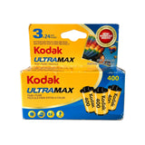 A box of Kodak Ultramax 400 color film rolls, showing three yellow rolls with black caps on the front, photographed against a plain light background.