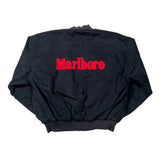 A black bomber jacket laid flat on a white background, featuring the word 'Marlboro' in bold red letters across the upper back.