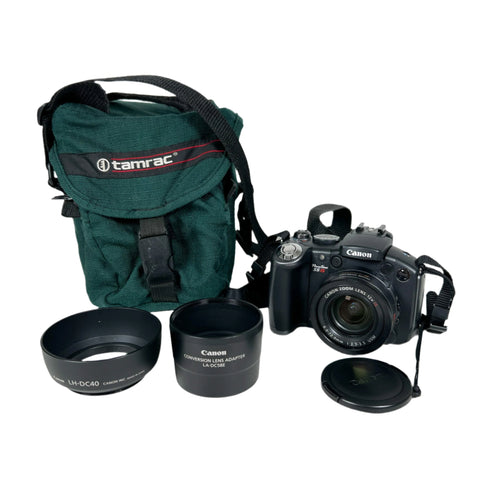 Canon camera with lens, hood, and Tamrac bag on a white background