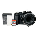 Nikon camera with battery and 8GB SD card on a white background