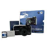 Canon digital camera with packaging and memory card on a white background