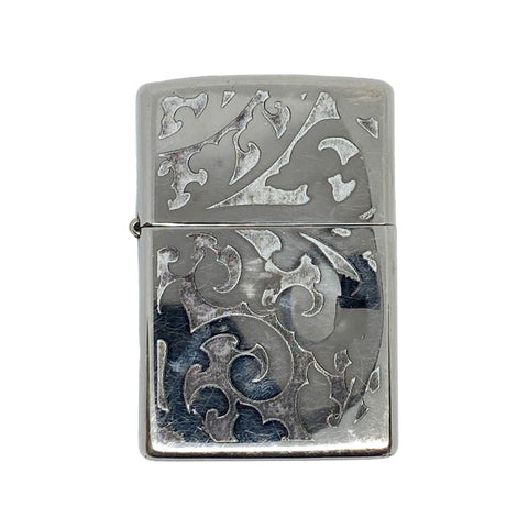 Silver zippo lighter with decorative patterns on a white background