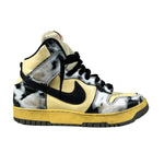 Sneaker with black, yellow, and white design on a gray background