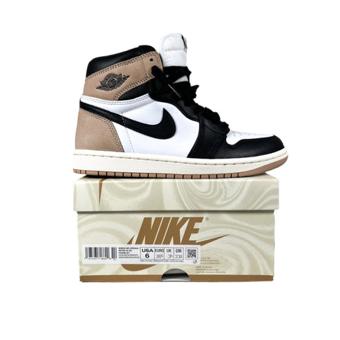 Black, white, and brown sneaker on a Nike box with a gray background