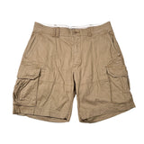 A pair of men's tan cargo shorts with multiple flap pockets, laid flat on a white background.
