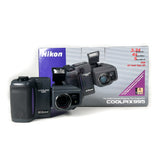Nikon Coolpix 995 digital camera with accessories and packaging on a white background