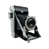 Vintage camera with a silver lens on a white background