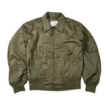 An olive green nylon bomber jacket laid flat on a light gray background. The jacket features a zippered front, a pointed collar, ribbed knit cuffs and hem, and multiple utility pockets.