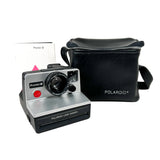 Polaroid camera with black carrying case on a white background
