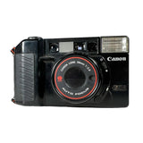 Black Canon camera with red lens on a white background