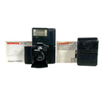Vintage Minox camera with flash and accessories on a white background