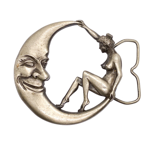 Bronze brooch with a crescent moon and a woman sitting on it against a white background