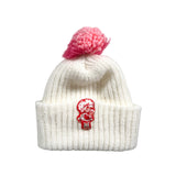 White knit hat with red pom-pom on a light gray background