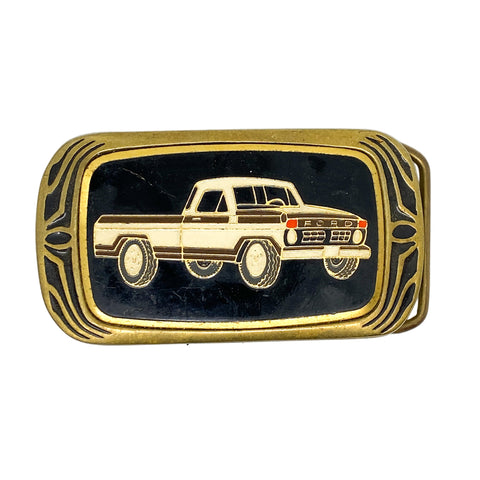 Belt buckle with a gold border and black background featuring an illustration of a truck.