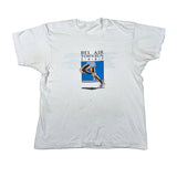 A white short-sleeve t-shirt laid flat on a light gray background, featuring a vintage graphic print of a track athlete with the text 'BEL AIR TOWN RUN' and '1-2-9-5' on the chest.