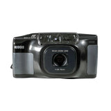 A vintage Nikon film camera with a black body and gray grip panels, photographed against a plain white background.