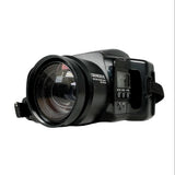 A black Genexon G2000 handheld video camera with a large front lens, shown on a light gray textured background.
