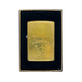 A vintage brass Camel lighter with a black velvet-lined presentation box, photographed against a white textured background.