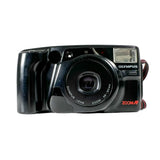 An Olympus ZoomAF compact instant camera in glossy black, shown from the front against a light gray background.