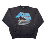 A black long-sleeve crewneck sweatshirt featuring a Pittsburgh Penguins graphic on the front with the word 'Penguins' in light blue and a penguin on a hockey puck.