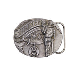 A silver-toned oval metal belt buckle featuring embossed relief artwork of a firefighter holding a hose, with the words “SHRINER” and “SERVING THE COMMUNITY,” plus a side loop for the belt.