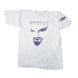 A white vintage graphic t-shirt featuring a purple stylized face print and the text 'DRACULA RISING' on the front, laid flat on a light background.