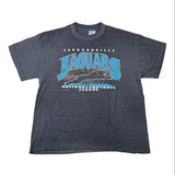 A dark heather gray short-sleeve t-shirt featuring a Jacksonville Jaguars graphic on the front, laid flat on a light background.