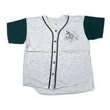 A short-sleeve button-front baseball-style shirt laid flat on a white surface. The body is light heather gray with dark green sleeves and dark green trim, plus a small black floral graphic on the left chest.
