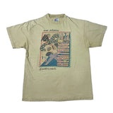 A vintage short-sleeve t-shirt in a light khaki-beige color, featuring a large graphic print on the front with a stylized figure and the text 'new orleans' and 'good times' in script.