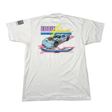 A white short-sleeve t-shirt laid flat on a white surface, showing the back side with a large graphic of a blue race car, 'Eddie Johnson' text, and a pink wing design. A small black print is visible on the left sleeve.