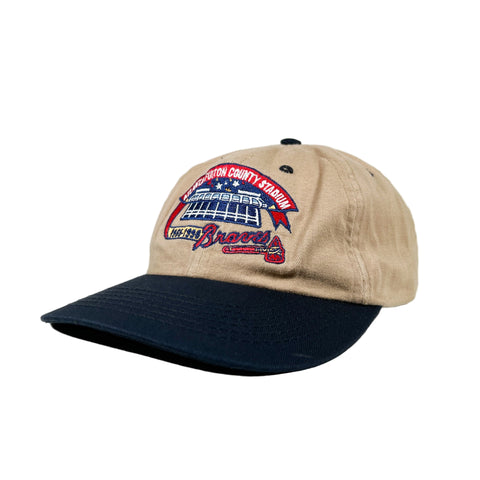 Beige and navy baseball cap with logo on a white background