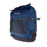 A blue JanSport backpack with a front mesh pocket and dark gray base, photographed on a plain light background.
