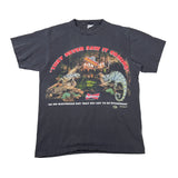 A vintage black graphic t-shirt featuring two chameleons in front of a house with the text 'THEY NEVER SAW IT COMICALLY' and a Budweiser logo on the front.