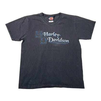 A faded black short-sleeve t-shirt with a distressed blue and white Harley-Davidson logo printed on the chest, laid flat against a white background.