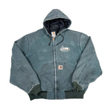A faded blue Carhartt zip-up hooded jacket laid flat on a white fabric background. The jacket features a front zipper, drawstring hood, kangaroo pockets, ribbed cuffs and hem, and a small Carhartt logo patch on the pocket.