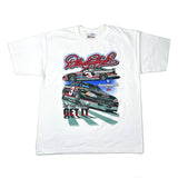 A white short-sleeve graphic T-shirt laid flat on a white surface, featuring NASCAR driver Dale Earnhardt and two race cars with Goodwrench and Budweiser branding. The shirt is photographed from above, with blue jeans visible at the bottom edge.