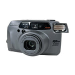 Gray Pentax camera with 'IQ Zoom' on a white background