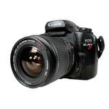Canon EOS ELAN 7 DSLR camera with a 18-55mm lens, shown on a light gray background.