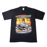 A black short-sleeve graphic T-shirt laid flat on a white background. The front features a large printed design with the words 'Winner of a Champion,' oversized reflective gold sunglasses, a black race car, and stylized orange script text.