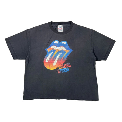 A vintage black short-sleeve t-shirt featuring the iconic Rolling Stones tongue and lips graphic in blue, orange, and yellow, with 'ROLLING STONES' text printed below it.