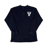 Folded navy blue shirt with a white logo on a light gray background