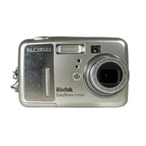 A silver Kodak EasyShare CX7530 digital camera with a textured metallic front panel, a prominent lens on the right, and a flash window on the left, photographed against a neutral light gray background.