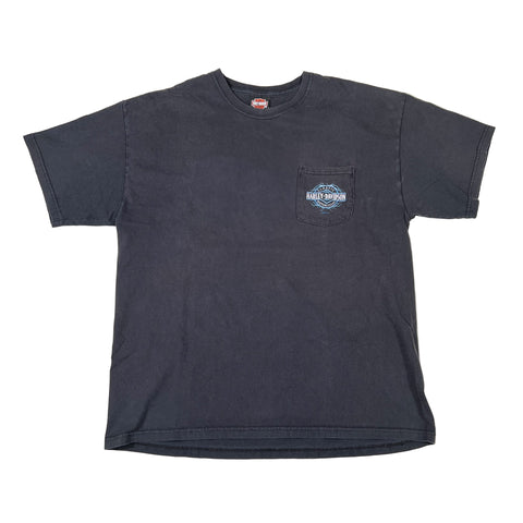 faded black t-shirt with a logo on the chest pocket against a white background