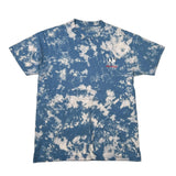 A short-sleeve crewneck t-shirt featuring a blue and white tie-dye pattern, with a small embroidered logo on the left chest depicting a camel and the text 'Camel Brand'.